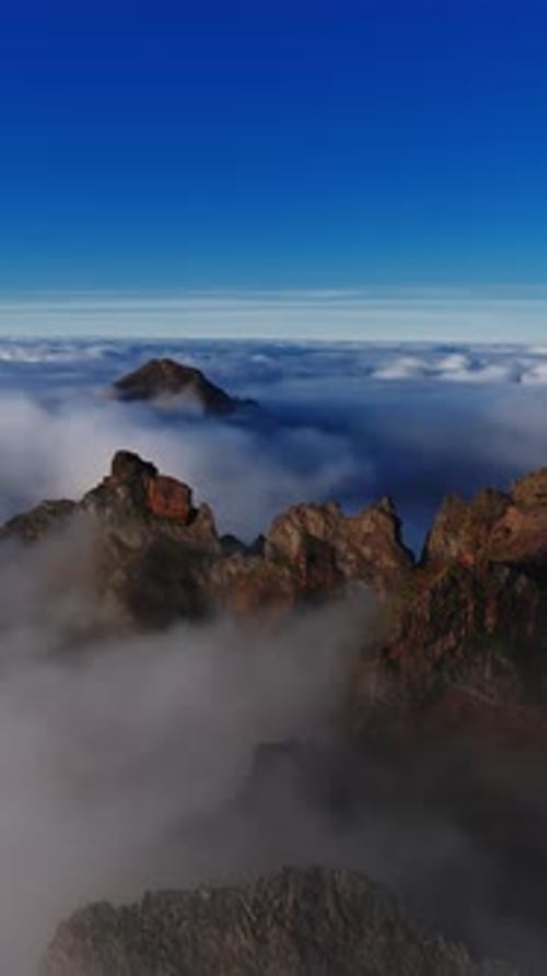 Vue aérienne des sommets de Madère s'élevant à travers les nuages à l'heure d'or