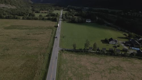 Aerial View Of Asphalt Road In The Middle Of Green Agriculture Farmland - drone shot
