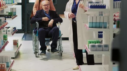 Pharmacist Consults with Senior Man in Wheelchair