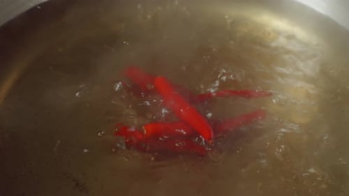 Close Up Of Chili Dropped Into The Boiling Soup Pot. Sukiyaki Or Shabu