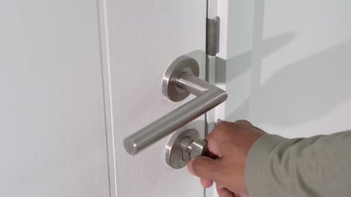 Turning the lock to open the door.