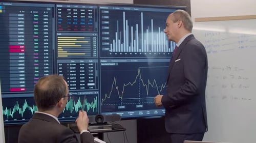 Men Discussing Data on Interactive Display in Office