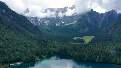 Picturesque lake Lago Fusine in Italy. Fusine lake with Mangart peak on background. Popular travel d
