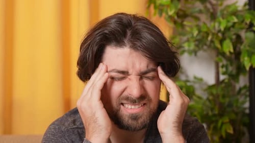 Adult Man Sitting on Sofa Close Up Shot Man Has Headache Painful Expression Massaging Temples