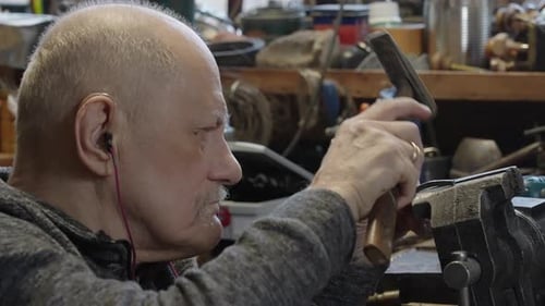Senior Elderly Master Jeweler in Wheelchair Works in a Workshop