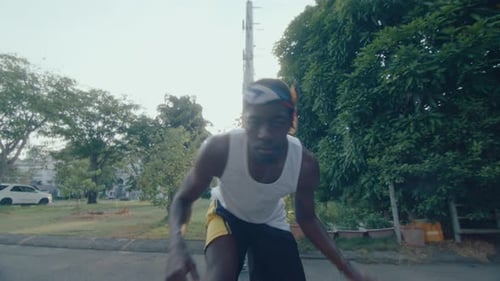 Jeune homme afro-américain dribble au basket en plein air