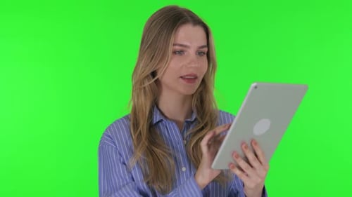 Young Woman Using Digital Tablet on Green Background
