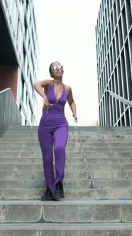 Stylish Woman Dancing on Concrete Steps in Urban Setting