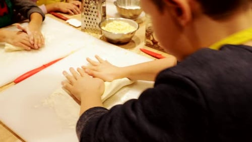 Boy Rolling Dough in Cooking Class 89 Years