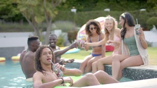 Diverse young adults enjoy a pool party outdoors