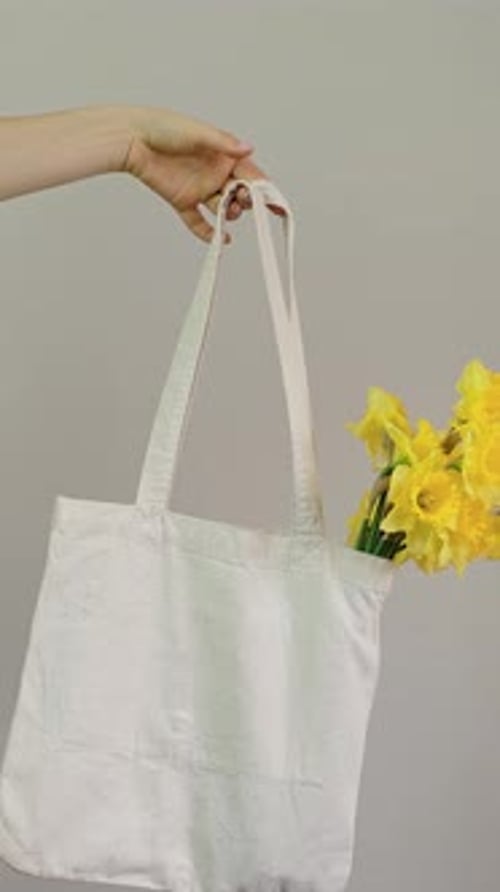 Niña colocando flores en una bolsa, entrega de flores en una nueva envoltura floral, para todas las celebraciones: 8 de marzo, Virginia