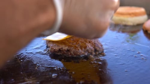 chef is cooking burgers on grill