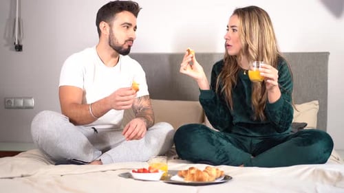 A smiling couple having breakfast in bed at home, lifestyle on a romantic Valentine's evening, 4k vi