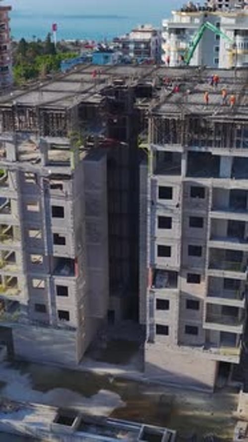 Vídeo vertical de un equipo de trabajadores de la construcción construyendo activamente una nueva casa moviendo materiales y