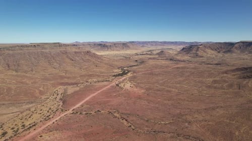 Aerial video of a safari on a dirt road, over a desert landscape, Namib Desert, Namibia