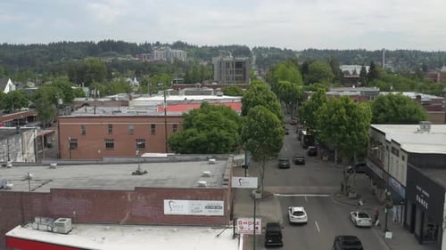 Cars Driving On The Road Between Buildings In Puyallup, Pierce County, Washington - aerial drone