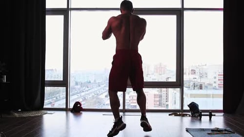 Sports Training in Studio with Panoramic Windows Muscular Man Performing Shadowboxing