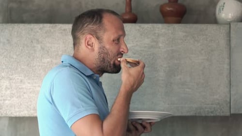 Man with Beard Eating Toast in Modern Home