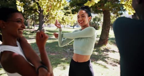 Women Stretching Arms Together in a Park