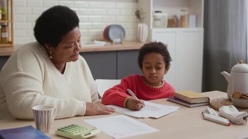 African American Kid in Sweater Practicing Handwriting