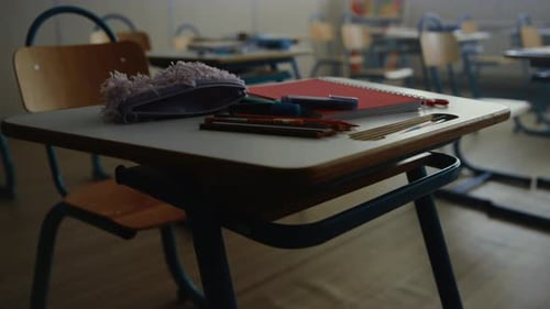 Material escolar sobre el escritorio en un aula vacía para el concepto educativo