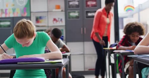 Portrait of happy diverse schoolchildren at desks in school classroom