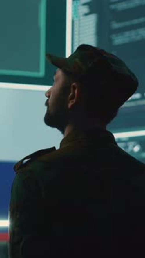 Soldier Standing in Front of Computer Screens