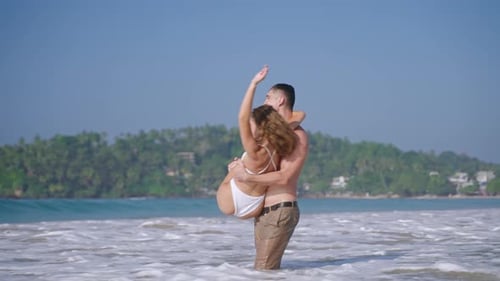 Fit Athletic Man Spinning Woman in the Sea Smiling Couple Kissing and Having Fun in the Ocean Water