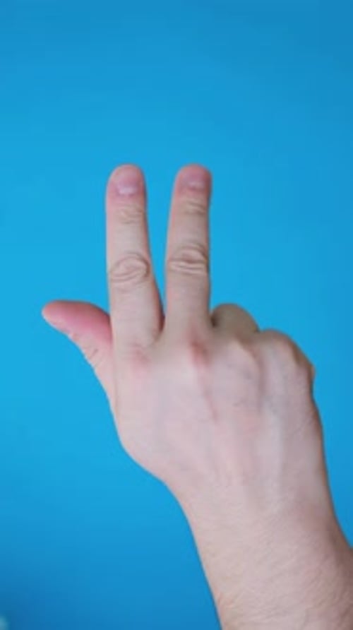 Counting fingers with hand against colorful blue background
