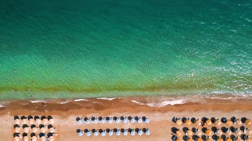 Topdown View of Sandy Beach with Sun Umbrellas and Turquoise Sea Water