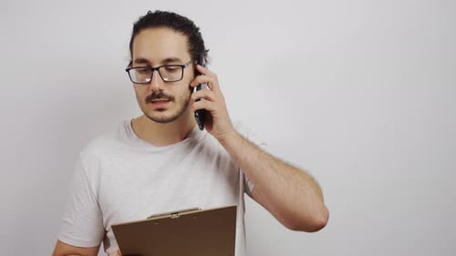 Young Adult Man Talking on Phone with Clipboard