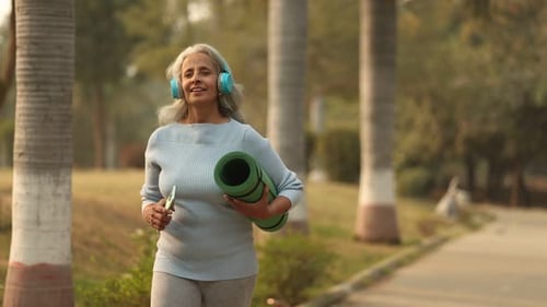 Older Woman Enjoys Yoga In the Park During Sunny Day
