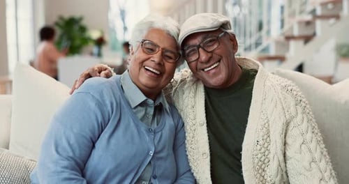 Senior Adults Smiling and Embracing on Sofa