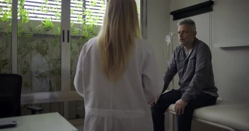 Mature Man Talking to Doctor in Examination Room