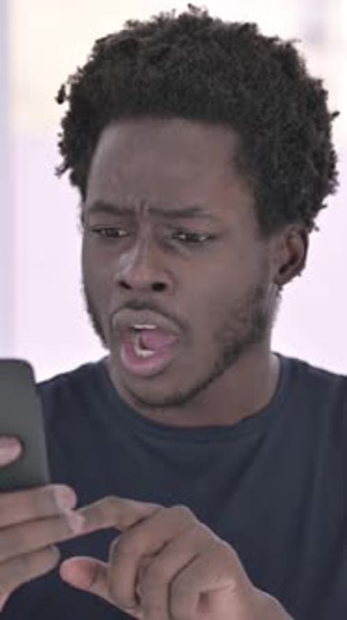 Excited Young Man Reacting to Phone News