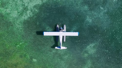 Vertikaler Luftabstieg über einem Wasserflugzeug, das auf türkisfarbenem Wasser in Key West angedockt ist