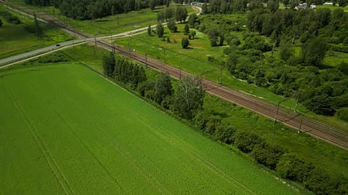 Die malerische Luftaufnahme zeigt üppige grüne Felder entlang von Bahngleisen in einer malerischen ländlichen Gegend