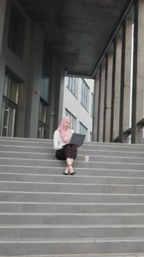 Vertical Screen Young Muslim Woman Sitting on Stairs Near Business Center and