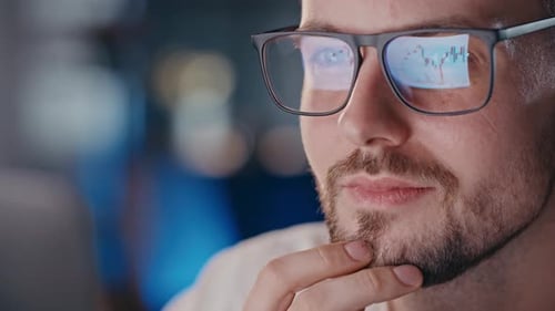Man with Glasses and Stock Market Reflection