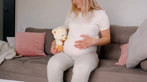 Mulher grávida e ursinho de pelúcia branco