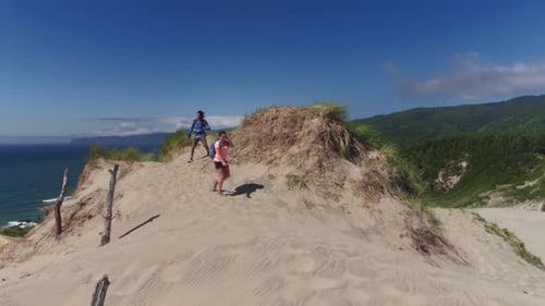 Couple Hiking On Sand Dunes At Beach