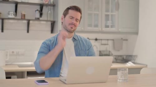 Man with Neck Pain Works at Home on Laptop