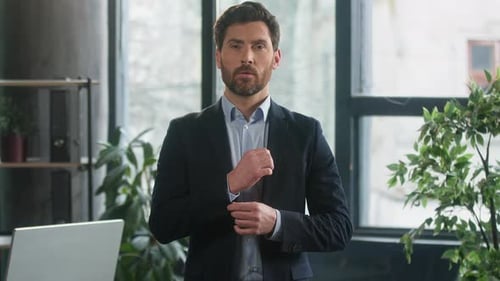Man in Suit Adjusting Cuffs and Crossing Arms