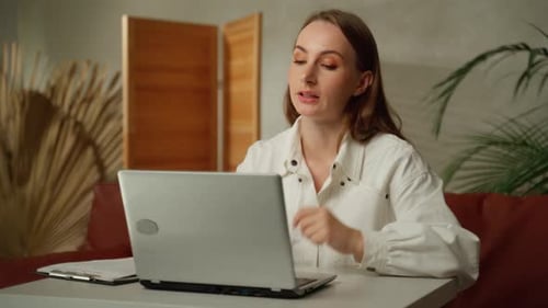 Woman Talking on Laptop in Home Office