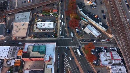 A high angle, aerial view of a busy intersection by Long Island Railroad elevated train tracks.