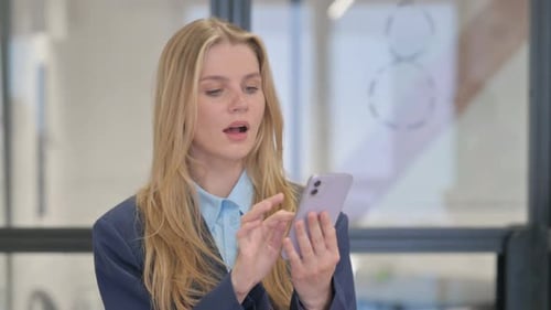 Woman Using Phone in Modern Office