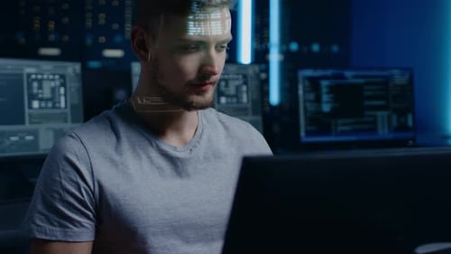 Man Coding at Computer Terminal in Dark Room