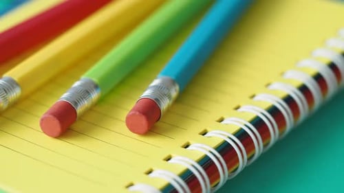 Bright Pencils and Notebook Lying on Blue Table