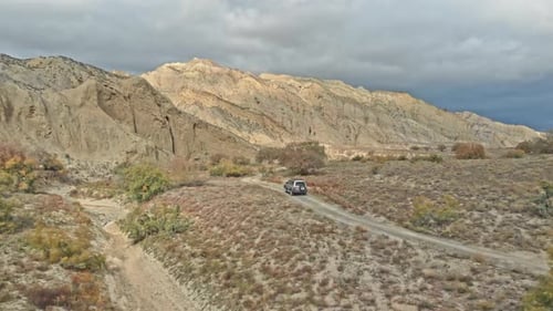 Aerial top down view drone of 4x4 car driving on gravel trail path