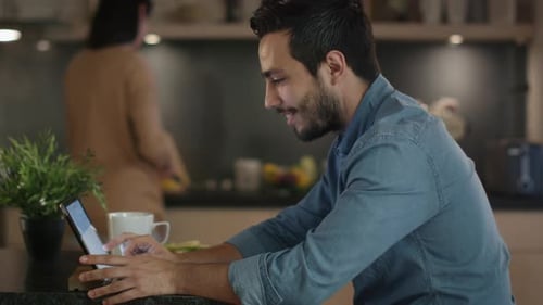 Man Using Tablet in Modern Kitchen at Home